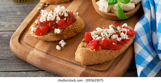 Bruschetta with tomatoes, feta cheese and basil. Traditional Greek snack on wooden background. Selective focus. - Powered by Shutterstock