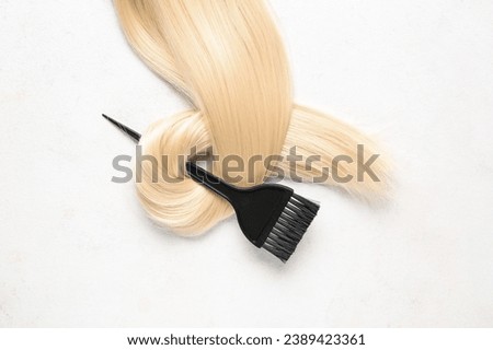 Brush and blond strand on white background