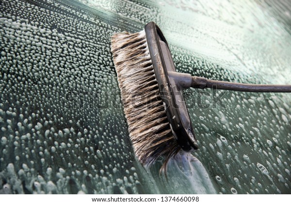 Brush for cleaning glass. Car wash with a brush,\
hand wash