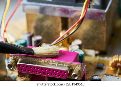 Brush Cleaning The Old Motherboard From Dust And Dirt.