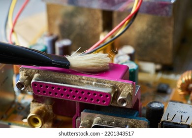 Brush Cleaning The Old Motherboard From Dust And Dirt.