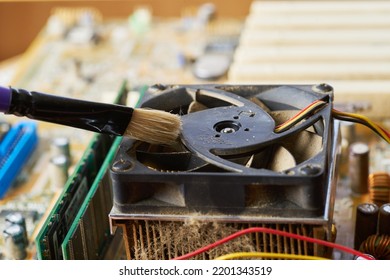 Brush Cleaning The Old Motherboard From Dust And Dirt.