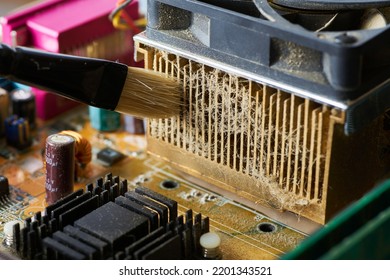 Brush Cleaning The Old Motherboard From Dust And Dirt.