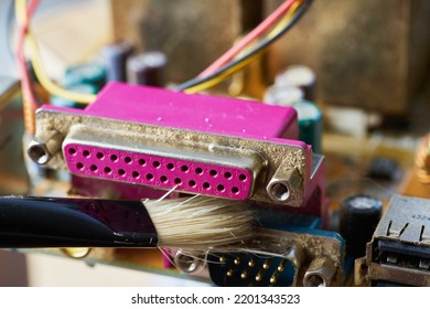 Brush Cleaning The Old Motherboard From Dust And Dirt.