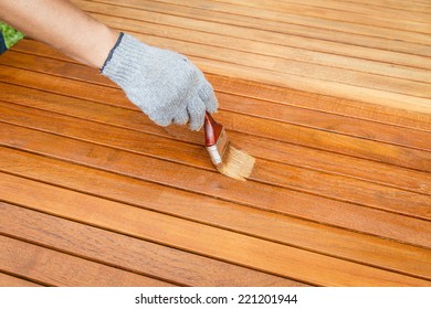 Brush in hand and painting on the wooden table - Shutterstock ID 221201944
