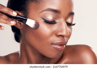 Brush on more of your beauty. Studio shot of a beautiful young woman applying blush with a makeup brush. - Shutterstock ID 2147754979