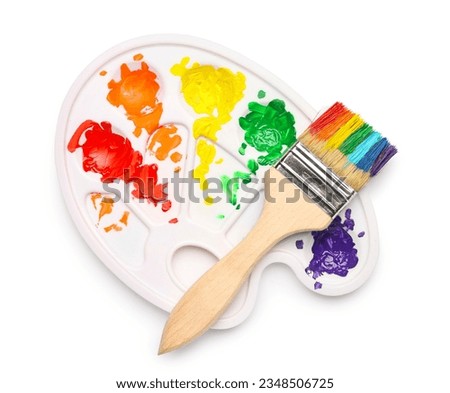Brush and palette with colorful paints on white background