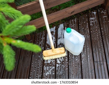 Brush and plastic canister with detergent on a wooden board, wooden terrace. Technologies and tools for cleaning surfaces. - Shutterstock ID 1763310854