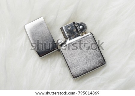 brushed chrome lighter with windproof isolated over white fur.