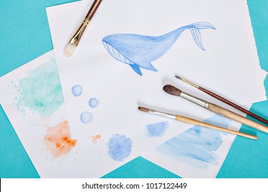 brushes and drawing with a whale on the color bright blue background