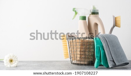 Brushes, sponges, rubber gloves and natural cleaning products in the basket.  Eco-friendly cleaning products