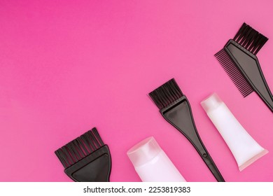 brushes and tubes for coloring hair on a pink background, copy space - Shutterstock ID 2253819383