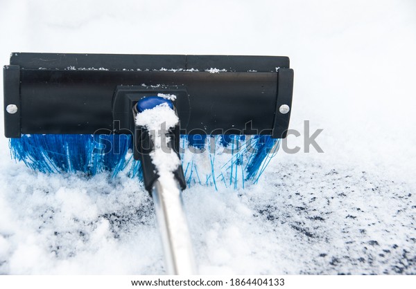 Brushing off\
the snow from the car. Removing cleaning the snow from the window\
of an automobile. Winter\
conception