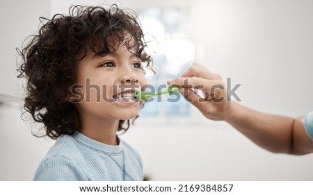 Brushing your kids teeth properly helps prevent cavities and infection. Shot of a father brushing his little sons teeth in the bathroom at home.