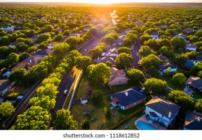 Brushy Creek Suburb Homes above Neighborhood in Austin , Texas suburb of Round Rock , TX aerial drone view high above Texas Hill Country houses golden hour sunset sun rays and lens flare