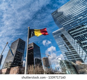 Brussels, Belgium - 03 10 2019: Contemporary glass and steel skyscrapers of the Little Manhattan financial and business district with a Belgian flag