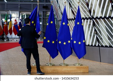 Brussels, Belgium. 28th May 2019.An official adjusts an EU flag in the lobby of the European Council building during the EU Summit.