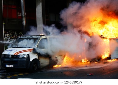 Brussels, Belgium. 30th November 2018. Demonstrators light a police van on fire during a protest of the yellow jackets. 