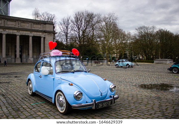 Brussels / Belgium - February 16, 2020: Love bug parade,\
volkswagen beetle parade, blue car with red hearts at Parc du\
Cinquantenaire 