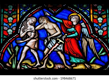 BRUSSELS, BELGIUM - JULY 26, 2012: Adam and Eve expelled from the Garden of Eden on a stained glass window in the cathedral of Brussels, Belgium. 