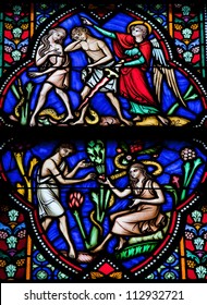 BRUSSELS - JULY 26: Stained glass window depicts Adam and Eve eating the Forbidden Fruit and being expelled from the Garden of Eden in the cathedral of Brussels on July, 26, 2012.