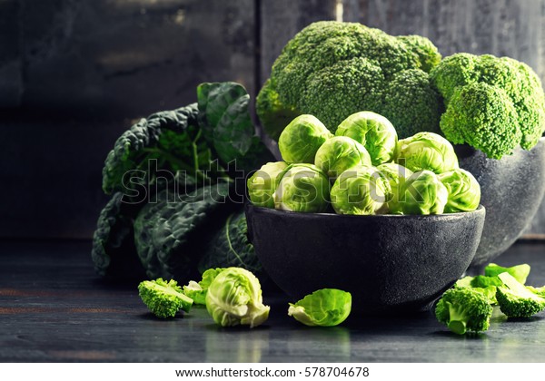 Brussels Sprout with Broccoli, kale, and  on black\
wooden table. Selective\
focus.
