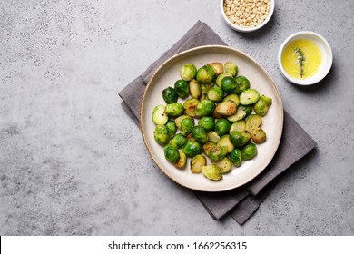 Brussels sprouts roasted with butter on gray slate background. Vegan Food Concept. Copy space, top view, flat lay