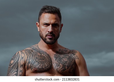 Brutal angry gang man lifestyle, serious handsome guy. Close up portrait of guy with serious profile face on sky. Bare strong naked torso.