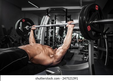 Brutal Athletic Man Pumping Up Muscles On Bench Press