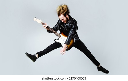 Brutal bearded man jumping with electric guitar. Rock musician. Heavy metal player. Music star.