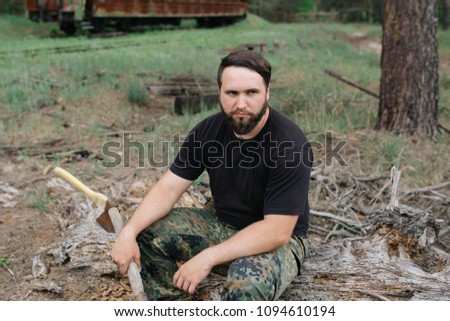 Similar – Foto Bild bärtiger Jäger, der auf der Wurzel eines trockenen Baumes sitzt.