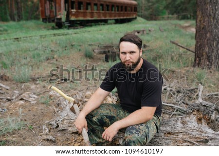 Similar – Foto Bild bärtiger Jäger, der auf der Wurzel eines trockenen Baumes sitzt.