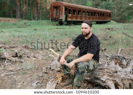 Similar – Foto Bild bärtiger Holzfäller mit einer Axt, die neben einem rostigen Zug sitzt.