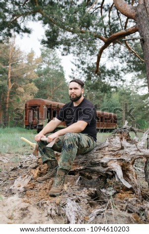 Similar – Foto Bild bärtiger Jäger, der auf der Wurzel eines trockenen Baumes sitzt.