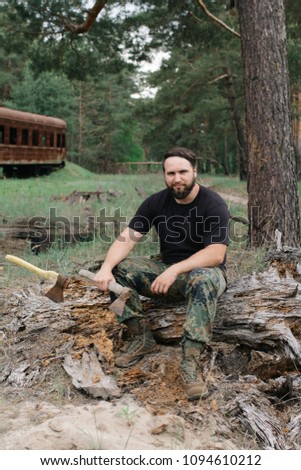 Similar – Foto Bild bärtiger Holzfäller mit einer Axt, die neben einem rostigen Zug sitzt.