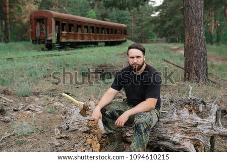 Similar – Foto Bild bärtiger Holzfäller mit einer Axt, die neben einem rostigen Zug sitzt.