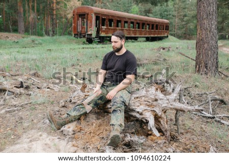 Similar – Foto Bild bärtiger Holzfäller mit einer Axt, die neben einem rostigen Zug sitzt.