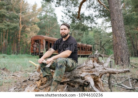 Similar – Foto Bild bärtiger Holzfäller mit einer Axt, die neben einem rostigen Zug sitzt.