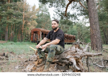 Similar – Foto Bild bärtiger Holzfäller mit einer Axt, die neben einem rostigen Zug sitzt.