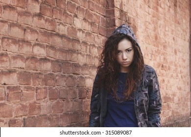 Brutal Girl In The Hood Against The Wall. Difficult Childhood, A Difficult Teenager, Uncontrollable. Pissed. The Evil Eye. Androgynous Appearance. Brutal Girl. Girl With A Hostile Look. Troubled Teen.