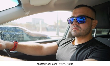 The Brutal Guy Is Sitting In The Car, Talking On The Phone And Smoking. The Tough Guy Is Talking On The Phone While Sitting In The Car. Close Up Photo Side View. Conversation, Technology Concept.