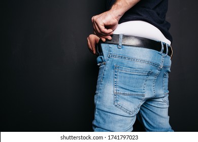 Brutal Guy In White Underpants Wears Skinny Jeans.
Concept: A Man Is Going To Work In The Morning, Pulls On Jeans. Spring Style In Street Clothes. 