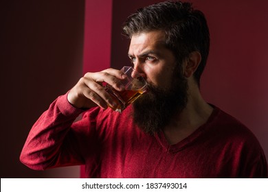 Brutal man drinks whiskey. Degustation and tasting. Man holds glass of whiskey. Strong alcohol.