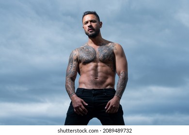Brutal man, handsome serious male model. Tattooed and elegant hipster. Strong muscular male body, muscles guy.
