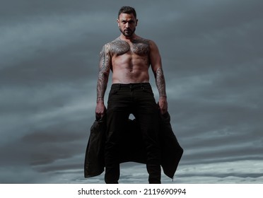 Brutal man, handsome serious male model. Strong muscular male body, muscles guy. Fashion male model with leather jacket vogue style. Naked male shoulders, topless athletic body.
