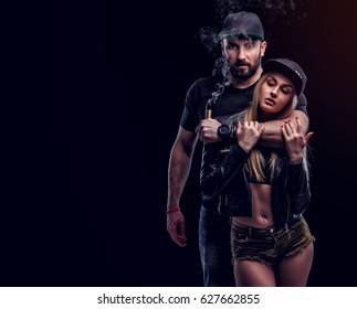 Brutal Man And Sexy Woman Are Vaping. Studio Shooting. Black Background.