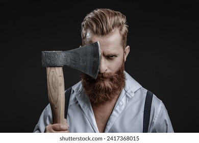 Brutal man in suspenders with ax isolated on black. Mature redhead man with hairstyle. Brutal male fashion style. Male brutality. Vintage brutality guy with ax in retro suspenders. Barbershop concept