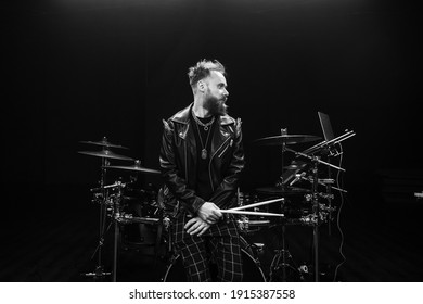 brutal portrait of a man musician with a beard and in black clothes on the background of musical instruments drums - Powered by Shutterstock