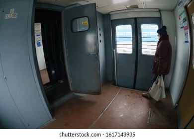 Bryansk, Russia - January 3, 2020: Comuter Train Interior. Vestibule Of The Commuter Train. One Local Woman Standing Here. Lifestyles Concenpts. Fish Eye Lens.