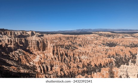 Bryce National Park's mesmerizing hoodoos beneath a clear sky. Nature's artistry carved in stone creates a stunning and timeless landscape.